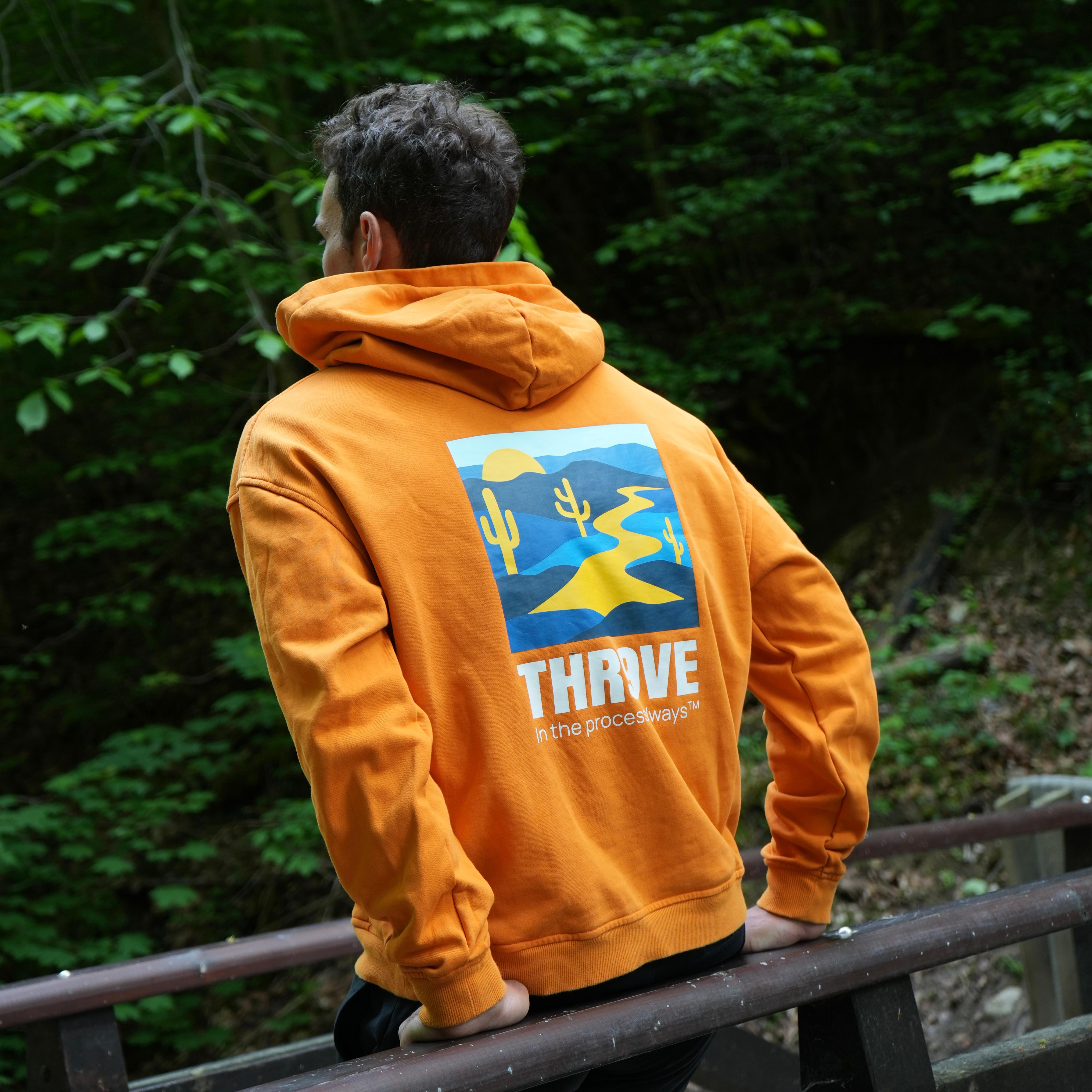THR9VE Organic Cotton Hoodie in warm orange — back view, lifestyle shot