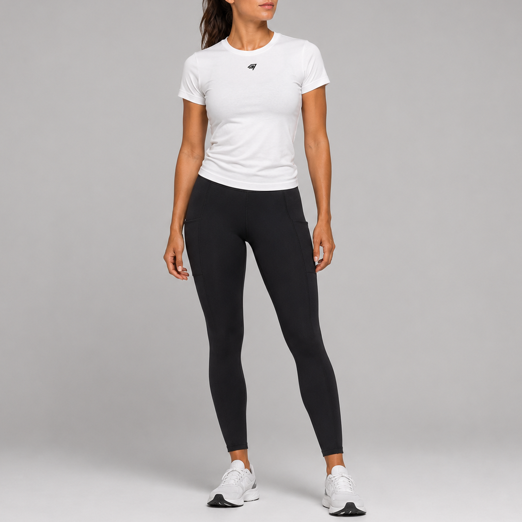 A woman modeling a white short-sleeve athletic T-shirt and black leggings against a light gray studio background.